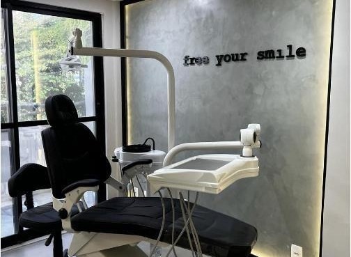 Consultório com cadeira e parede com letreiro iluminado