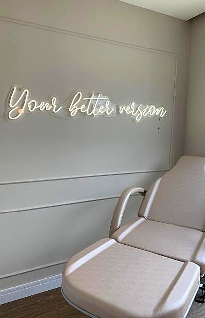 Sala de procedimentos com poltrona e letreiro em neon
